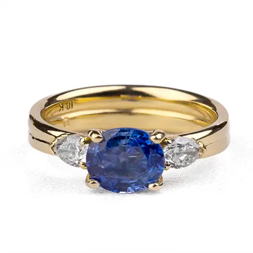 18k yellow gold engagement ring set with oval blue sapphire and two pear shaped diamonds, Davidson Jewels